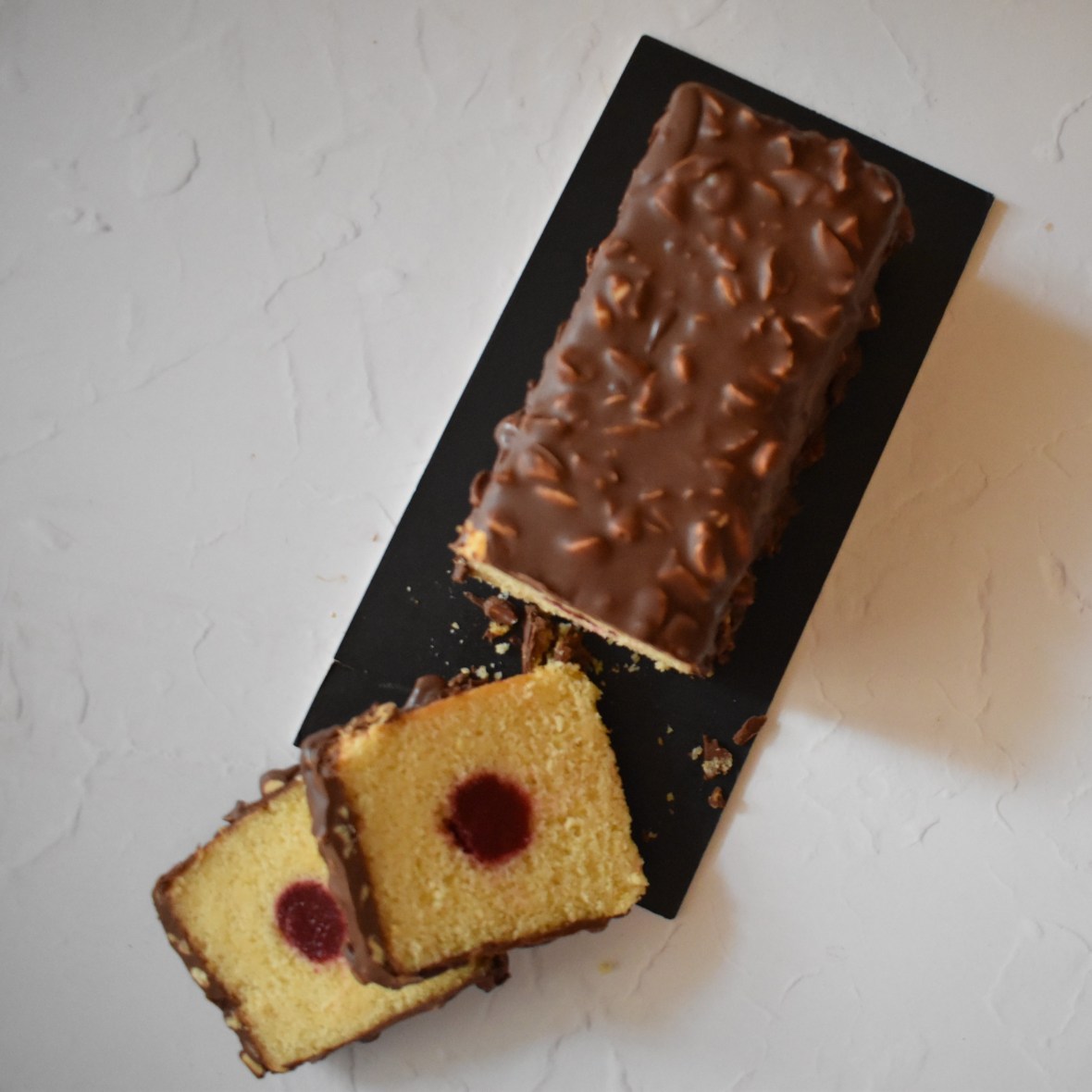 Holey Moley lemon surprise cake with raspbery insert and rocher chocolate glaçage